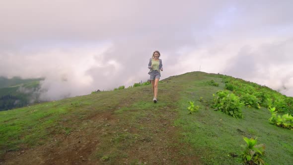 the girl walks on tops of mountains. Amazing atmospheric moment