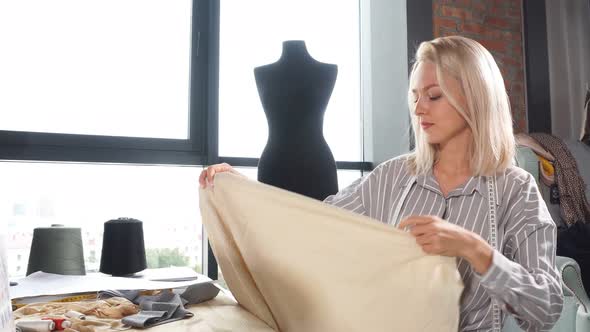 Young Blonde Dressmaker Repairing Client's Clothes