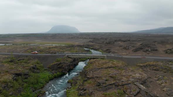 Drone View River Flowing Over Rocky and Desolate Landscape in Iceland