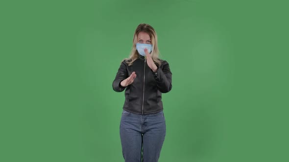 Portrait of Beautiful Young Woman in Medical Protective Face Mask Looking at Camera and Strictly