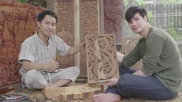 Asian Males Showing Carved Wood And Thumb Up