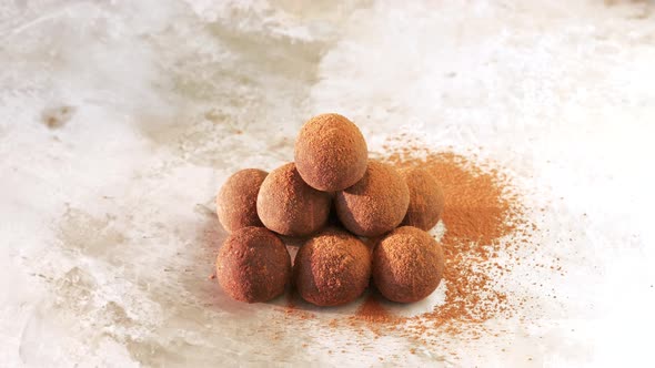 Homemade Raw Vegan Sweet Energy Balls Lying in Stack Cacao Powder Sprinkled