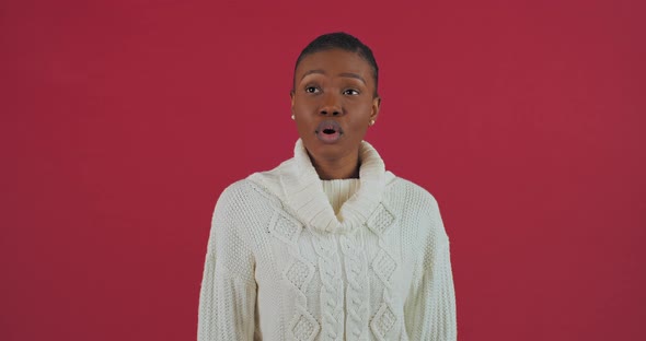 Portrait Studio Shooting African American Woman Ethnic Girl Model in White Sweater Isolated on Red