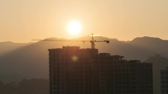 Sunrise Over a Tower Crane on Construction Site with a Skyscraper in the City, Timelapse