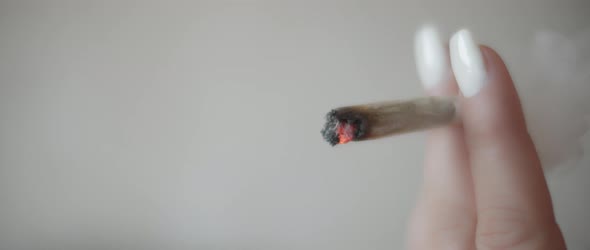 Close up of a woman smoking a cannabis joint, slow motion