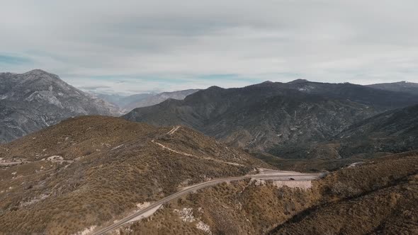 Drone shoots the road with a car on a gray mountain in Sequoia National Park, California, USA