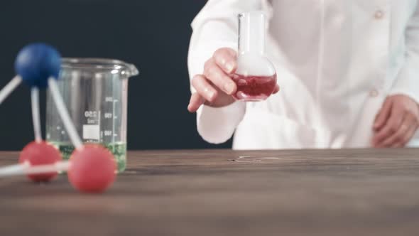 Chemistry Teacher Putting Steaming Flask on Table