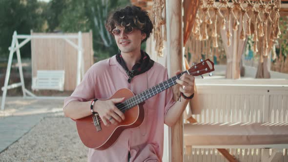 Guy Playing Ukulele on Beach