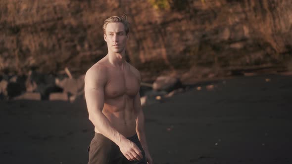 Athletic Caucasian Man Walking Topless on the Seashore After Workout