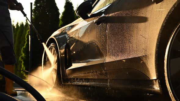 Men Washing His Car Using Pressure Washer