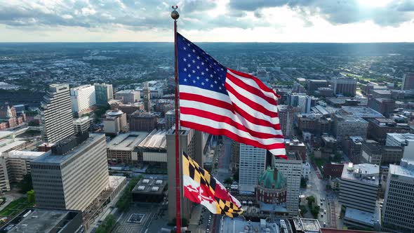 State of Maryland flag in downtown Baltimore MD USA. Aerial orbit of flags on summer day.