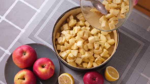 Apple Pie Preparation Series  Woman Pours Chopped Apples Into a Baking Dish