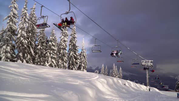 Ski Lift Carries Skiers and Snowboarders on the Mountain