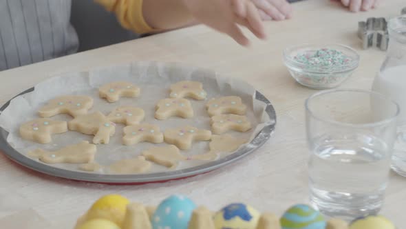 Hands of Girl Taking Baking Sheet with Easter Cookies