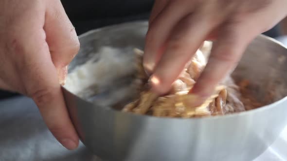 Chef is kneading dark gingerbread dough in a bowl