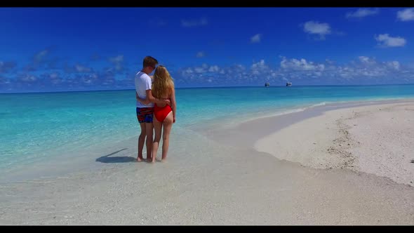 Young couple in love on marine tourist beach time by blue lagoon and white sandy background of the M