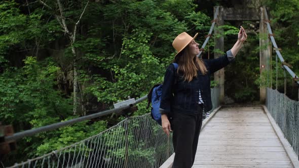 Millennial woman traveler makes selfie photo or video by her phone