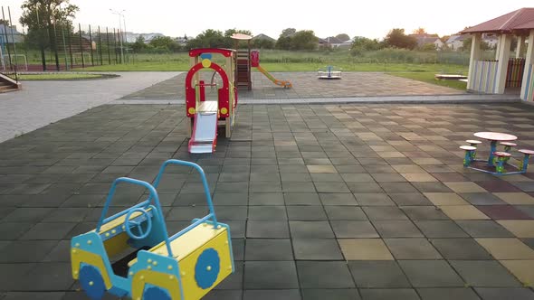 Footage on preeschool yard with swings, slides and modern daycare school building.