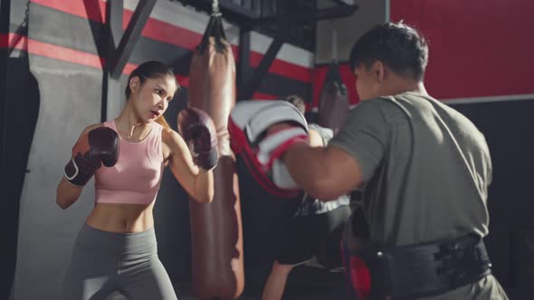 Asian Fitness instructor teach and motivate young active sportswoman exercising doing boxing.