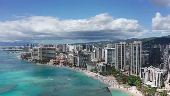 Aerial wide descending and panning shot of picturesque Waikiki Beach in Hawaii. 4K