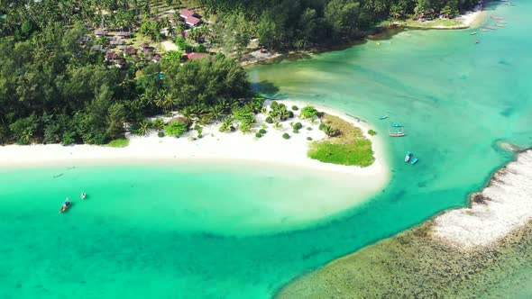 Aerial drone view panorama of tranquil lagoon beach lifestyle by blue green water and white sandy ba