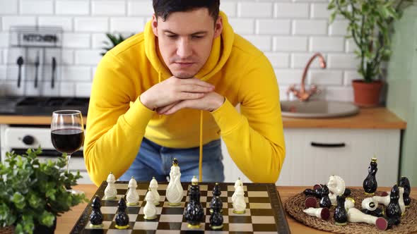 Young Man Playing Chess on Kitchen Table