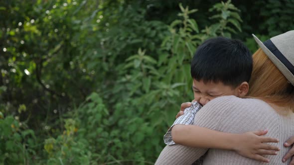 Happy family mom hugging her son