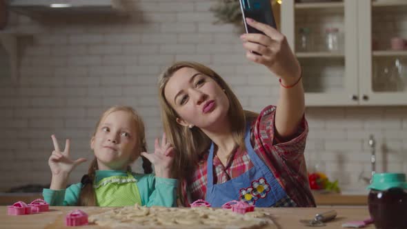 Mother with Daughter Taking Selfie Shot in Kitchen