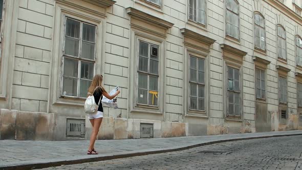 A tourist girl got lost with a map in her hands in the old city of Budapest