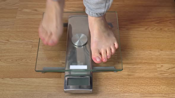 Women's Feet Stand on the Scales and Check Their Kilograms Top View