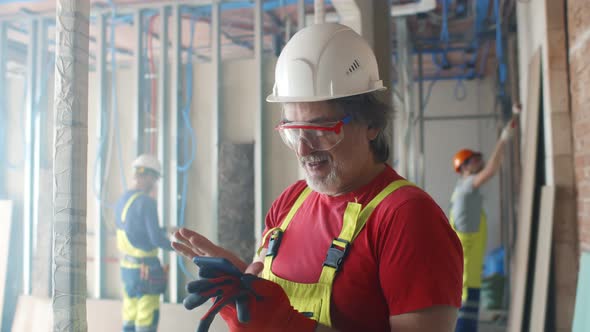 Building Site Worker Resting and Using Mobile Phone