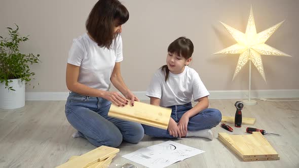 Happy Family Mother and Daughter Assembling Wooden Furniture Together