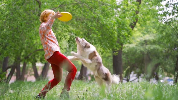 A Young Girl Is Playing with Her Dog in a Park