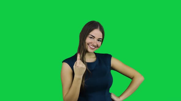 Girl call camera with one finger in front of a green screen