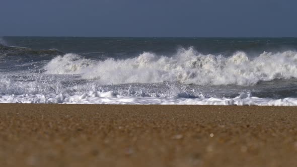 Portugal. Turbulent Atlantic Ocean and Sand Beach. Waves with Whitecaps Rolling on Coast Making Many