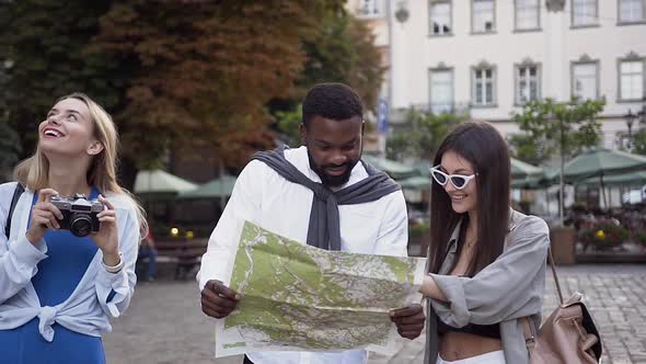 Woman Photographing Magnifincent Architecture Until Her Mixed Races Friends Looking at Tourist Map