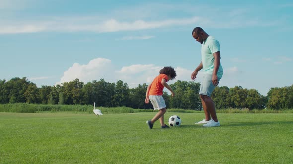 Family with Child Playing Football Game Outdoors