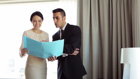 Business Team with Papers Working at Hotel Room 