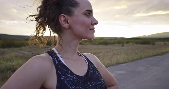 Woman Takes a Break From Running at Sunset