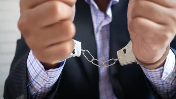 Man's Hand with Handcuff on Black Background