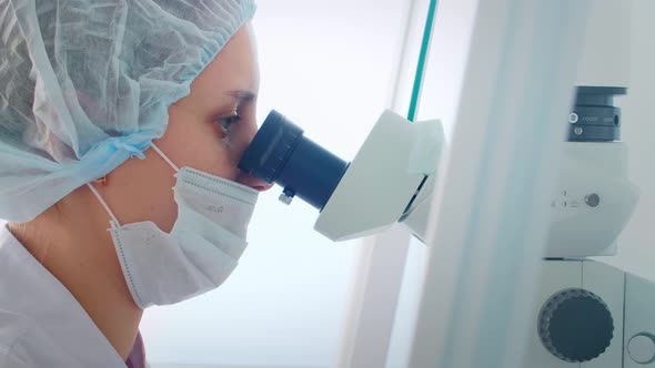 Female Scientist Looking Microscope Eyepiece. Portrait of Woman Scientist Looking Through Microscope alt