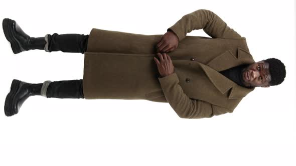 AfroAmerican Man in Brown Coat Stands Over White Background Isolated Full Shot Vertical Video