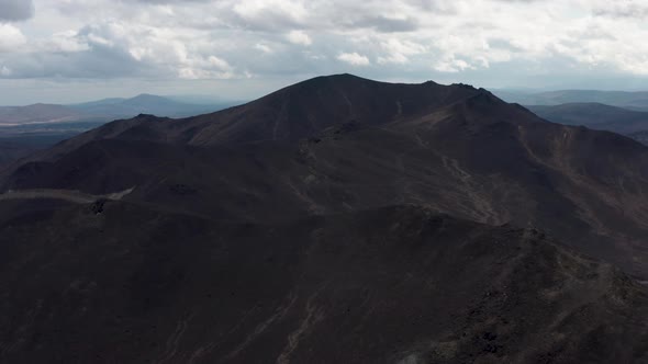 Aerial View of the Mountain Against the Background of Clouds and a Mountain Range