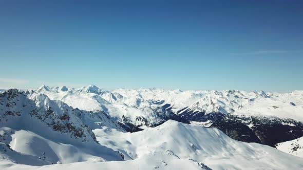 Aerial drone view of snow covered mountains in the winter.