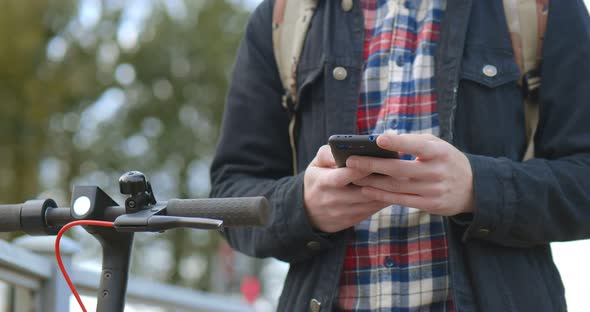 Close Up Image of a Man on an Electric Scooter Paying Online By Mobile Phone