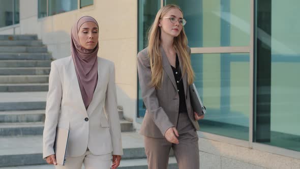 Serious Purposeful Colleagues Indian Girl in Hijab and Young European Woman Go to Office Together