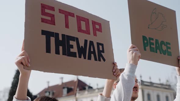 People Shake Posters and Chant Calling to Stop the War