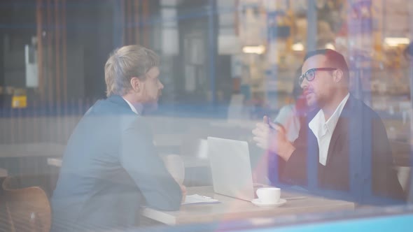 Office Workers Sitting on Coffee Break in Cafe and Working on Business Project