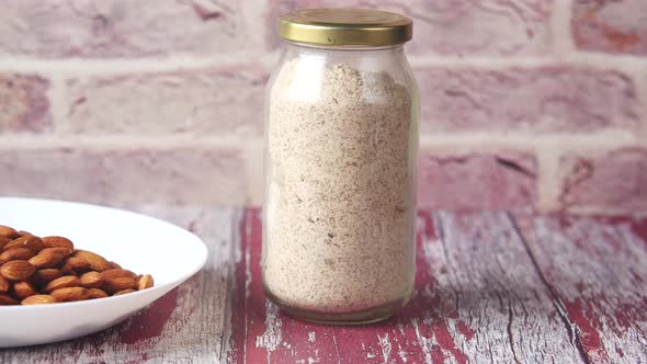 Almond Powder and Almond in a Jar on Table