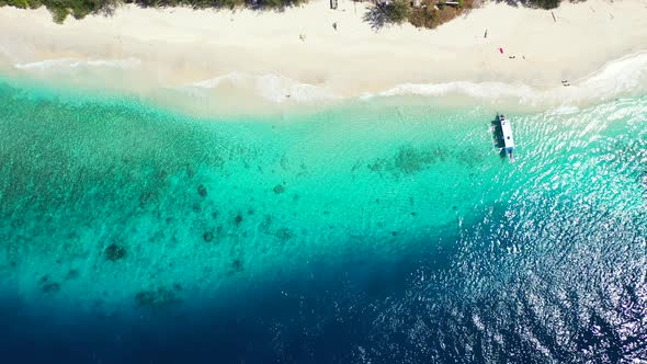 Beautiful overhead abstract shot of a sandy white paradise beach and aqua blue water background 